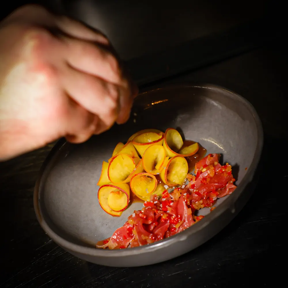Daniel plating a dish of tomato and courgette